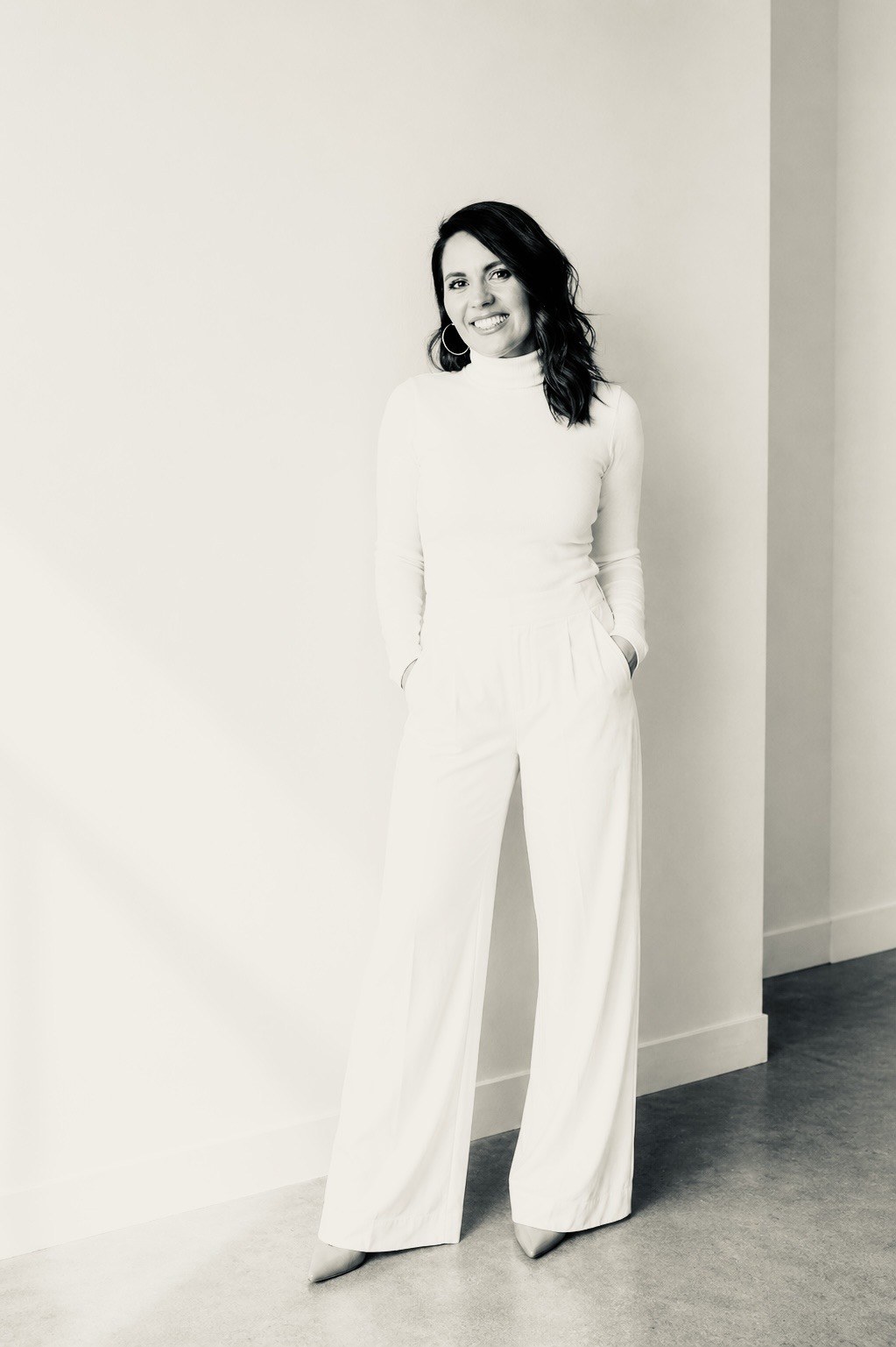 Vanessa Smith standing in a quiet studio, a composed black and white editorial portrait